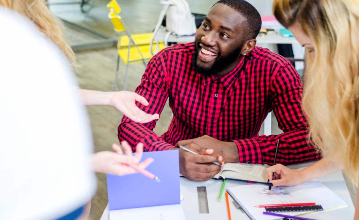 Consulente aziendale in dialogo con membri del team durante una sessione di lavoro
